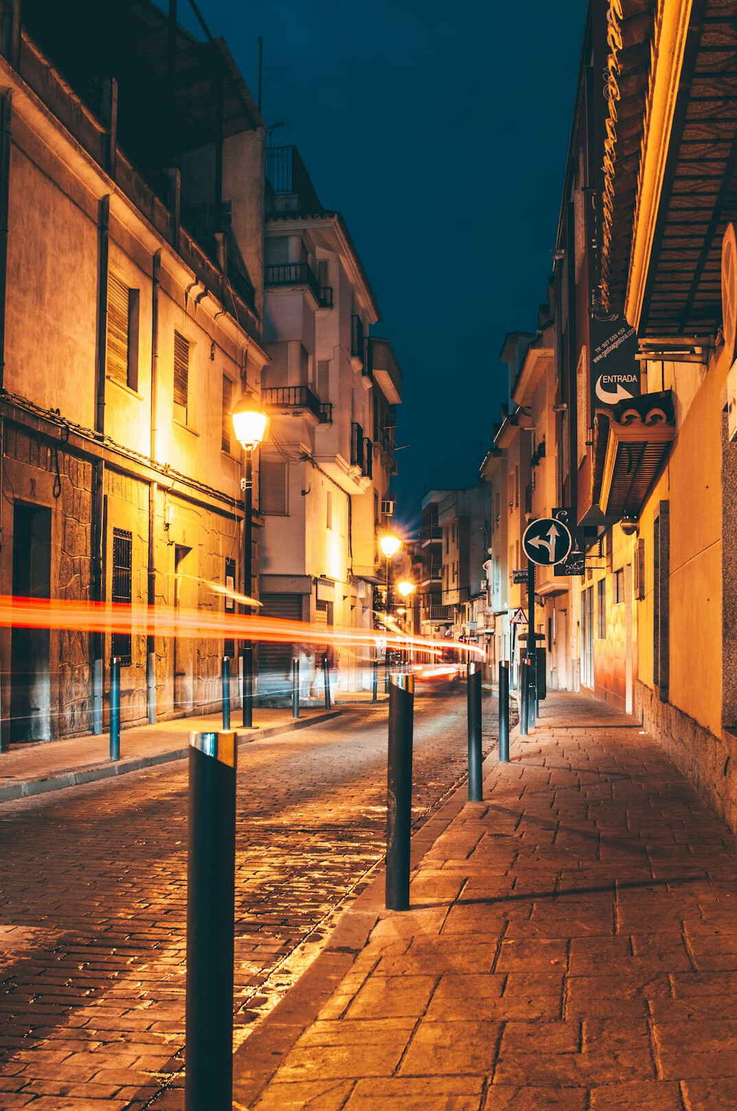 Quiet old city street at night with warm street lights